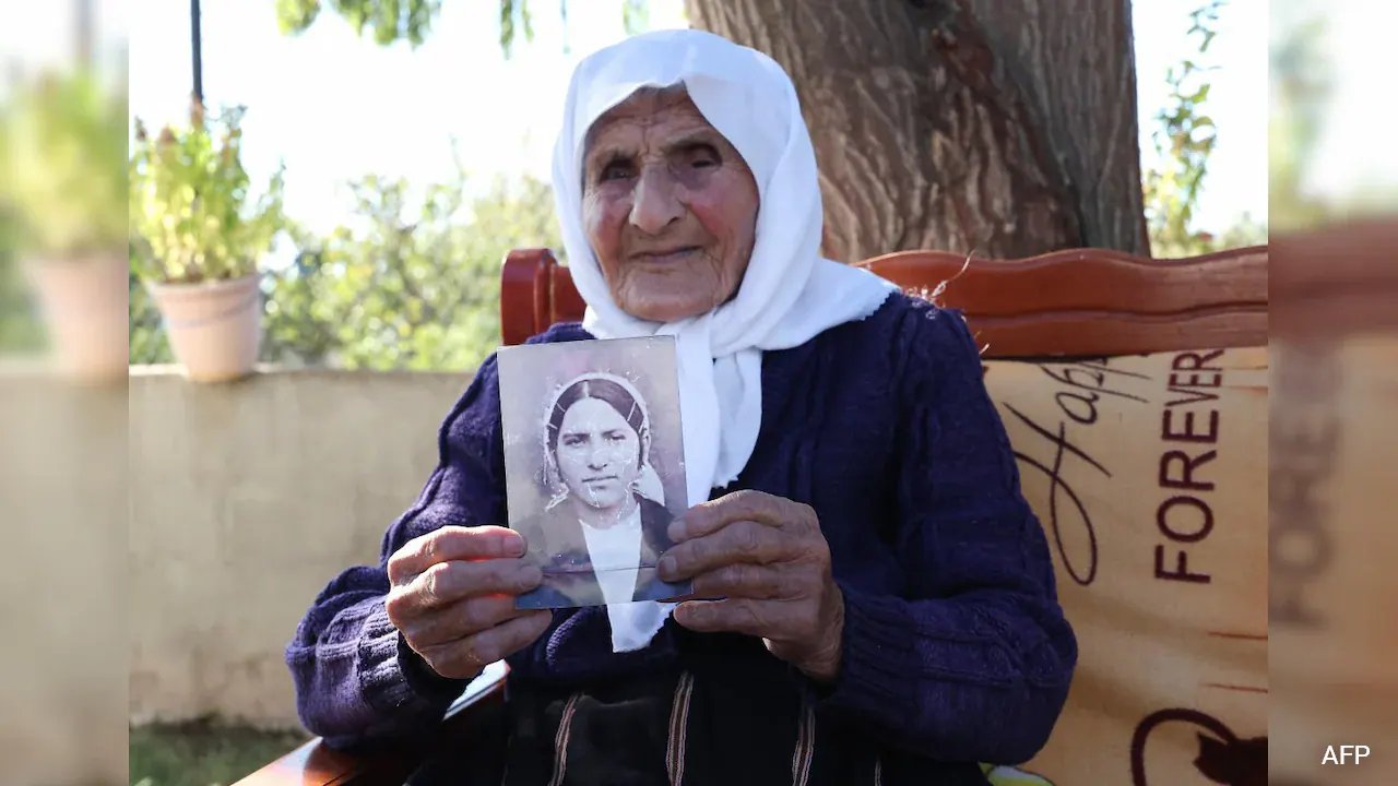The 117-year-old Qamile Marra holds a black and white photograph from her youth The 117-year-old Qamile Marra holds a black and white photograph from her youth